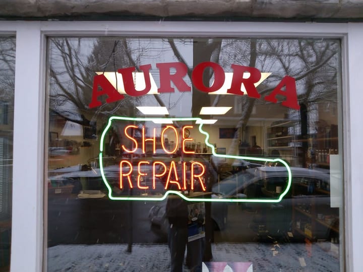 Aurora Shoe Repair window sign on North Plain Street