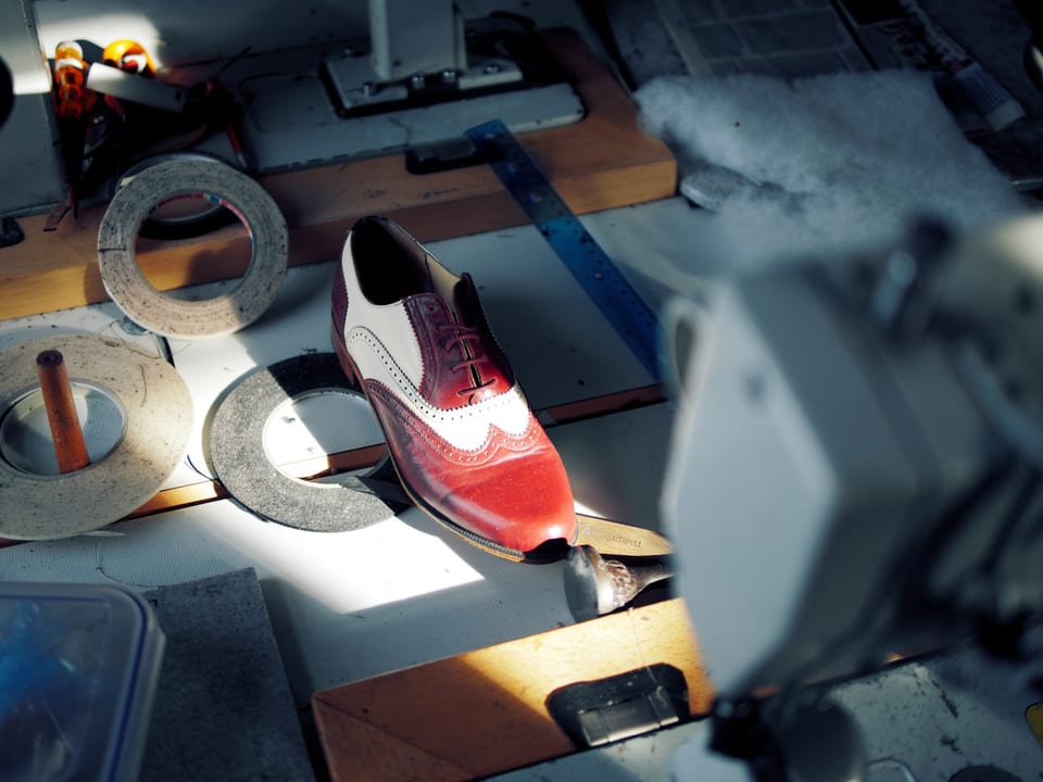 Shoe repair tools and leather shoe on a workbench